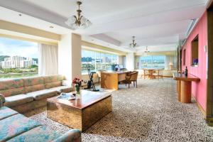 a living room with a couch and a table at Regal Riverside Hotel in Hong Kong