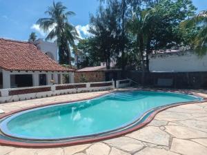 einen Pool in einem Hof mit einem Haus in der Unterkunft Carel Holiday Homes in Mombasa