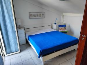 una camera con un letto e una coperta blu di Villetta sul mare a Termoli