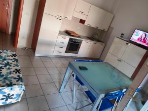 una piccola cucina con tavolo blu in una stanza di Villetta sul mare a Termoli