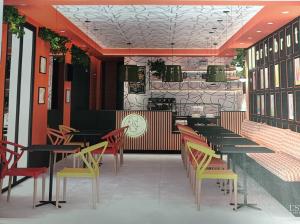 restauracja ze stołami i krzesłami oraz zegarem na ścianie w obiekcie Residencial Art Brut w mieście Castellón de la Plana