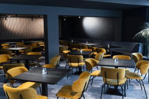 a restaurant with tables and chairs and a projection screen at Hostel SLEPS in Augsburg