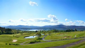 a golf course with a lake and mountains in the background at Luxurious Interior Designed Home in Kenmare