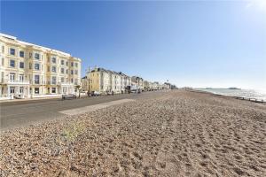Blick auf einen Strand mit Gebäuden und das Meer in der Unterkunft Modern Home for Small Groups by Stones Throw Apartments - Free Parking - Sea View in Worthing