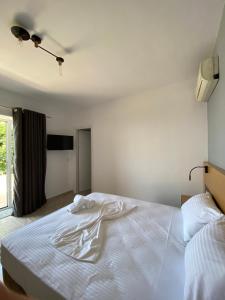 um quarto com uma cama branca e uma janela em EDGEWATER apartments em Saranda