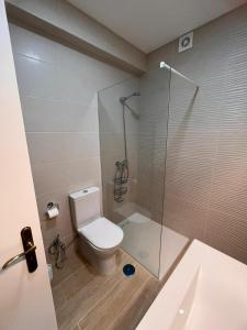 a bathroom with a toilet and a glass shower at Apartamento Solaris T1 - Férias Albufeira in Albufeira