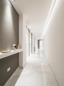 um corredor com piso em azulejo branco e um longo corredor em Savoia Rooms Roma em Roma
