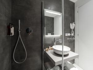 uma casa de banho com um lavatório e um chuveiro em Savoia Rooms Roma em Roma