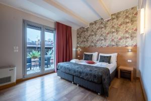a bedroom with a bed and a large window at Relais Bellaria Hotel & Congressi in Bologna