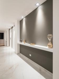 a hallway with a gray wall with a vase on it at Savoia Rooms Roma in Rome