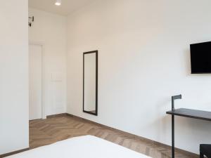 Habitación con espejo en una pared blanca en Savoia Rooms Roma, en Roma 54 fotos más