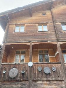 a wooden building with windows and a clock on it at Casa Leon in Vrin