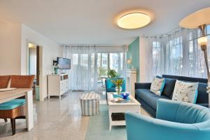 - un salon avec un canapé bleu et une table dans l'établissement Hansa-Residenz I Hansa-Residenz I Appartement 1, à Scharbeutz