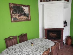 uma sala de jantar com uma mesa e uma parede verde em Noclegi u Barbary em Nasiczne