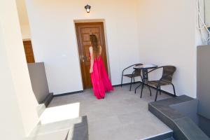 a woman in a pink dress standing in a room at Elafonisi Paradise with Parking, WiFi, - Walking Distance to the Beach in Elafonisi