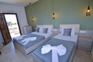 a bedroom with two beds with bows on them at Elafonisi Paradise with Parking, WiFi, - Walking Distance to the Beach in Elafonisi