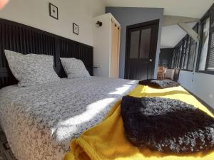 ein Schlafzimmer mit einem großen Bett mit schwarzen und weißen Kissen in der Unterkunft L'Inattendu in Saint-Sébastien-sur-Loire