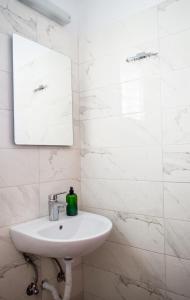 a white bathroom with a sink and a mirror at House Charistos in Neos Marmaras