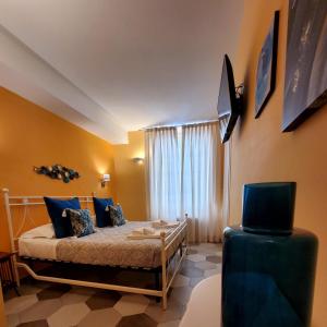 a bedroom with a bed with blue pillows and a television at Residenza FillAnfi in Lucca