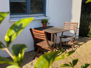 einen Holztisch und zwei Stühle neben einem Fenster in der Unterkunft Elbinsel-Home ‘Alpakaliebe’ in Hamburg