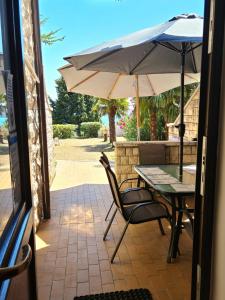 a table and chairs with an umbrella on a patio at Apartments Vila Toni in Portorož