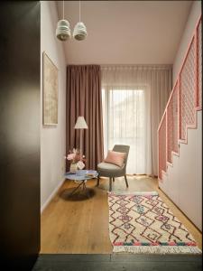 a living room with a chair and a window at Libertine Lindenberg in Frankfurt/Main