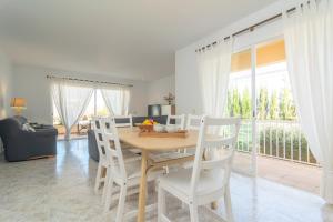 une salle à manger avec une table et des chaises blanches dans l'établissement Can Moragues & Martorell, à Badia Blava