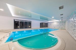 a large swimming pool in a building at Waterlane Apartment SPA&Wellness, Pool by Renters in Gdańsk