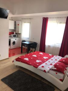 sypialnia z łóżkiem z czerwoną i białą kołdrą w obiekcie Jane House w Bukareszcie