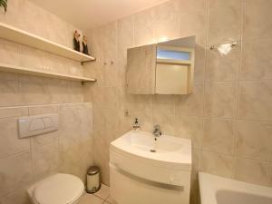 Un baño con un inodoro blanco y un lavabo. en Previnaireweg 22, en Callantsoog 9 fotos más