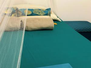 a bed with a curtain and a blue table at Petit Dyamant in Pointe-à-Pitre