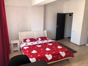 sypialnia z czerwonym łóżkiem z białym sercem w obiekcie Jane House w Bukareszcie