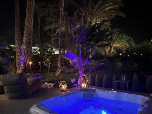 ein Pool in der Nacht mit violetten Lichtern in der Unterkunft Sun Club Luxus Bungalow Projecto 65 in Maspalomas