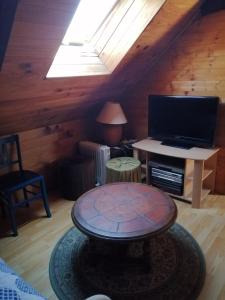 sala de estar con TV y mesa en Tyrbourg en Lopérec