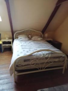 um quarto com uma cama com um edredão branco em Tyrbourg em Lopérec