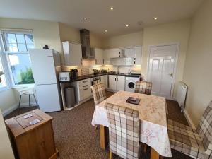 a kitchen with a table with chairs and a refrigerator at Upper Tresulian in Saint Mawes