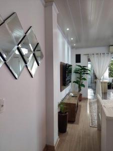 - un salon avec une télévision murale et une table dans l'établissement Casa em Gramado, à Gramado