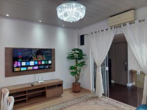 ein Wohnzimmer mit einem Flachbild-TV an der Wand in der Unterkunft Casa em Gramado in Gramado