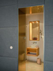 a bathroom with a shower and a sink and a mirror at Libertine Lindenberg in Frankfurt/Main