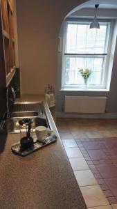 a kitchen counter with a sink and a window at Seaside, Exmouth Centre - sleeps 6+ in Exmouth