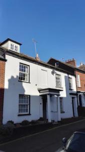 a white house on a street with a car parked in front at Seaside, Exmouth Centre - sleeps 6+ in Exmouth