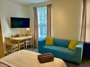 uma sala de estar com um sofá azul e uma mesa em Studio 5 mins walk from Seven Sisters Station em Londres