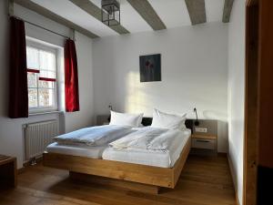 Schlafzimmer mit einem Bett mit weißer Bettwäsche und einem Fenster in der Unterkunft Gasthof Goldene Krone in Pottenstein