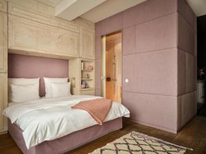 a bedroom with a large bed with a pink headboard at Libertine Lindenberg in Frankfurt/Main