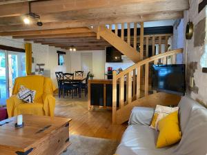sala de estar con sofá blanco y escalera de madera en Domaine de la Blanche Hermine en Plounérin