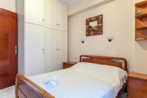 1 dormitorio con cama y espejo en la pared en CHRISTINE SEASIDE APARTMENTS IN CHANIA en Stalós