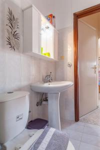 Baño blanco con lavabo y aseo en CHRISTINE SEASIDE APARTMENTS IN CHANIA en Stalós