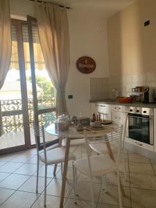 eine Küche mit einem Tisch und Stühlen sowie eine Küche mit einem Fenster in der Unterkunft La Corte di Silvia Malpensa in Cardano al Campo