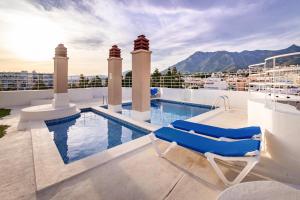 a balcony with a swimming pool and two lounge chairs at Mar de Alborán Center sea view in Marbella