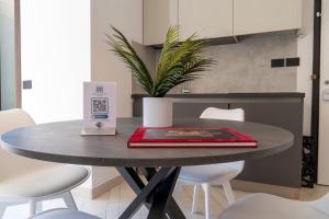 a table in a kitchen with a red folder on it at [GALLERIA DUOMO] Luxury Design Apartment in Brescia +14 photos